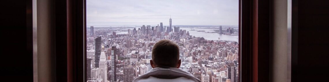 man in gray shirt looking at city buildings