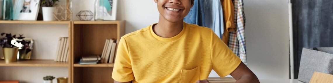 boy in yellow crew neck t shirt sitting on chair